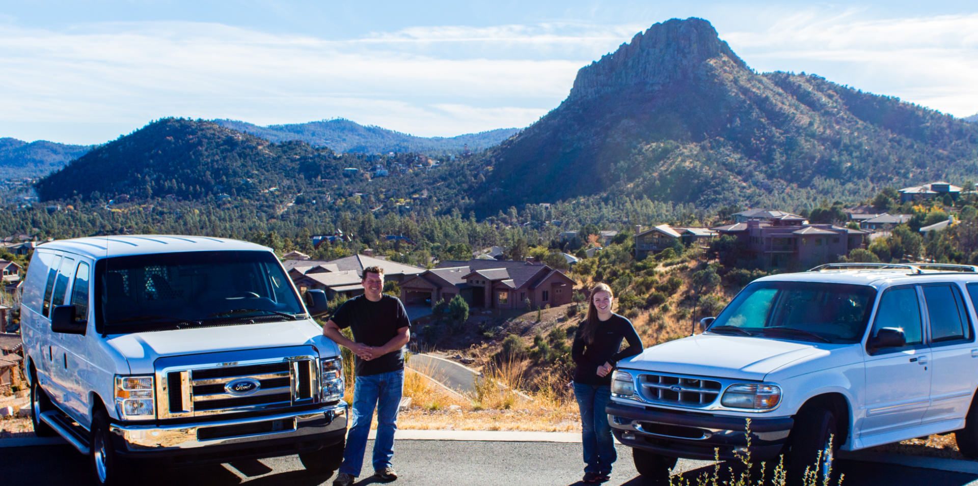 Two Accredited Locksmith service vans parked at a scenic overlook