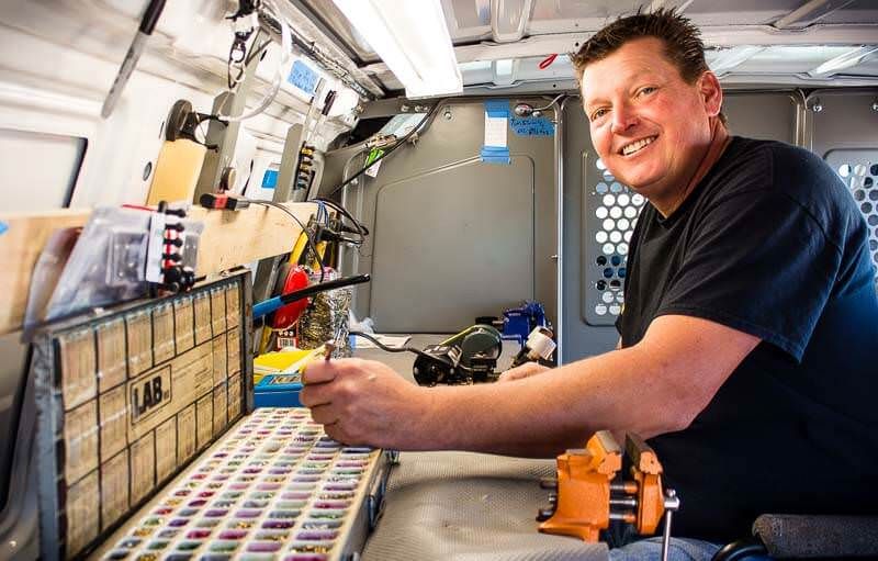 Jimmy working at the mobile locksmith workshop bench inside the van