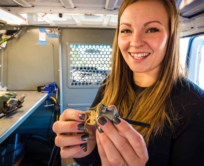 Locksmith employee holding a lock cylinder and key toward the camera